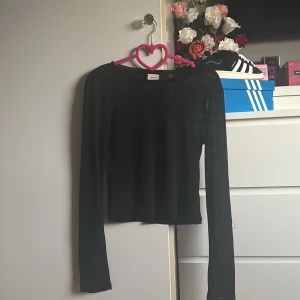 Svart långärmad tröja från Nelly - Säljer en svart  långärmad mesh tröja från Nelly. Perfekt för en enkel och klassisk look. Tröjan har en rund halsringning och är tillverkad i ett mjukt material, har ett hål vänstra handleden . Använd några gånger bara💕