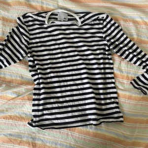 Svartvit randig långärmad tröja från 157 - Randig långärmad tröja från 157 i svart och vitt. Klassisk design med rund halsringning och smal passform. Perfekt för en enkel och stilren look. Tillverkad i mjukt bomullsmaterial.