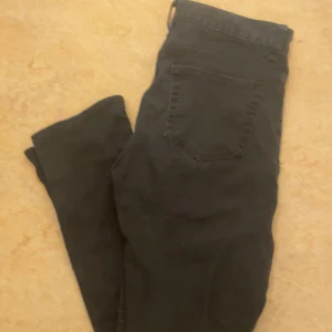 Svarta jeansbyxor - Svarta jeansbyxor med klassisk femficksdesign och raka ben. Byxorna har knapp och dragkedja framtill samt bälteshällor i midjan. Perfekta för en stilren och enkel look. ABS! Pris går att diskutera. (STORLEK 30/30)
