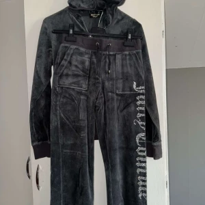 Mörkgrå velour hoodie från Juicy Couture - Mysig mörkgrå hoodie i velour från Juicy Couture med glittrande stenar och krona på ryggen. 