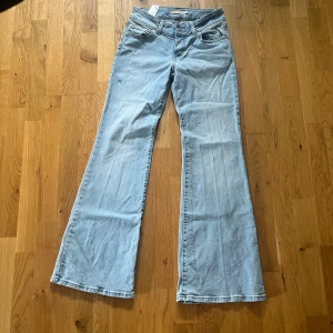 Ljusblå Superlow Flare jeans från Levi's - Säljer ett par ljusblå Levi's Superlow Flare jeans med utsvängda ben och klassiska bakfickor. Byxorna har låg midja och är tillverkade i mjukt denim. Perfekta för dig som gillar retrostil och vill ha ett par riktigt snygga jeans.