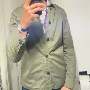 Olivgrön Morris overshirt  - Säljer den här helt sjukt sällsynta Morris overshirten köpt i Carl Otto, går inte att hitta online någonstans! Är sjukt unik med högsta kvalitet med 100% bomull har en unik förmåga att ge en ljus vintage fade i beskrivningen, fråga gärna om taggar och fler bilder!, använd vid två tillfällen endast, skick är alltså 10-10 Inga defekter. Riktigt bra passform, Storlek S slimfit passar långa personer som är mellan 184-187cm. Nypris 2100kr mitt pris 1799kr, priset kan diskuteras till en vis del.