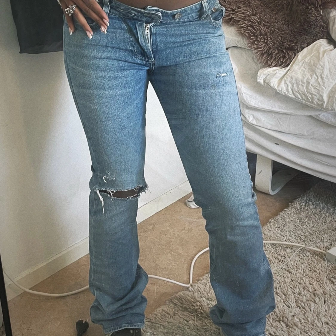 Blåa jeans med hål på knät och lår 