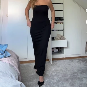 Svart axelbandslös långklänning - Säljer min svarta långklänning från nakd då den inte kommer till användning. Så fin!! Slutsåld på hemsidan i storlek S. Använd en gång. 