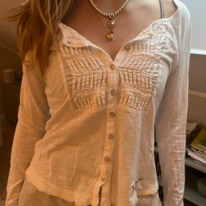 Vit tröja med knappar  - Säljer en jättesöt vit tröja med långa ärmar och knappar framtill. 