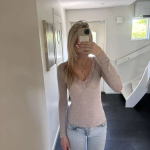 Lilla/rosa/beige långärmad intimissmi topp med spets - Säljer en intimissmi tröja med v-ringningarna  med fina spetsdetaljer. Perfekt att styla med jeans eller kjol för en enkel men snygg look.💕💕