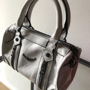 Vit Zadig och Voltaire väska  - Säljer denna snygga väska. Jag köpte den på Vinted så vet inte säkert om den är äkta därav priset. Säljer då den inte kommer till användning. Det finns ett längre band till. Pris kan diskuteras. 