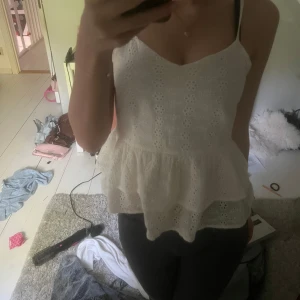 Vit sommar blus/ topp  - Säljer en söt vit topp med broderade blommor och volang nertill. Jätte fin samt perfekt till sommaren 