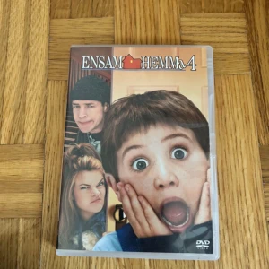 Ensam Hemma 4 DVD - Säljer filmen Ensam Hemma 4 på DVD. Omslaget visar huvudkaraktären med klassiskt chockat ansiktsuttryck och två andra karaktärer i bakgrunden. DVD-skivan har filmens titel tryckt på sig och kommer i originalfodral.