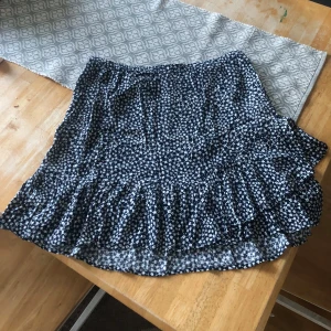 Blommig volangkjol från Lindex - Supersöt kort kjol med små vita blommor på mörkblå botten från Holly & Whyte/Lindex. Kjolen har volangdetaljer och resår i midjan. Perfekt inför sommaren!! Köpte för några år sen och har nog använt den 1-2 gånger så den är väldigt ny! Köptr för 400kr🌟 skriv vid frågor och funderingar💓