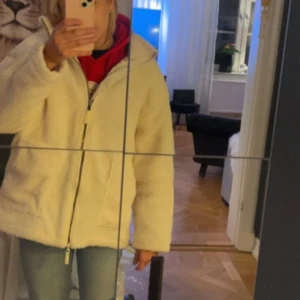 Vit teddyjacka med dragkedja - Säljer en fluffig vit teddyjacka med dragkedja framtill.