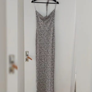 Mönstrad långklänning från I Saw It First - Säljer en långklänning med svartvitt grafiskt mönster från I Saw It First. Klänningen har smala axelband och öppen rygg.