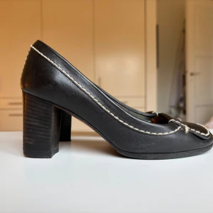 Mörkblå loafers med klack från Chloé i skinn, storlek 35 - Mörkblå loafers med klack från Chloé i läder med kontrasterande vita grova sömmar. Skorna har fyrkantig tå, markerad klack och diskret Chloé-logga framtill. Nyklackade och nysulade!