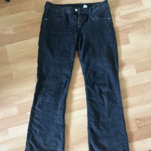 Lågmidjade bootcut jeans  - Svarta lågmidjade bootcut jeans från H&M i storlek 40. Jeansen är tillverkade i denim och har en snygg svart tvätt som passar till det mesta. Förekommer slitningar på insida lår men går att laga💗