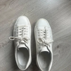 Vita sneakers med platåsula från Zara - Snygga vita sneakers från Zara med klassisk design och platåsula. Skorna har rund tå, snörning och är tillverkade i syntetmaterial. Använda fåtal gånger! 