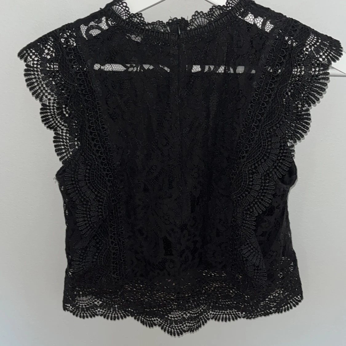 Svart spetsblus med volangdetaljer