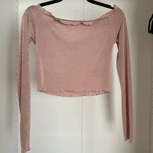 Rosa croppad offshoulder topp - Säljer en ljusrosa croppad topp med offshoulder och långa ärmar. Perfekt för dig som gillar trendiga.
