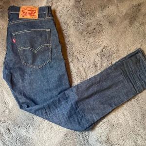 Levi's 512 mörkblå jeans W30 L32 - Säljer ett par Levi's 512 jeans i mörkblå denim med klassiska kontrastsömmar och femficksdesign. Modellen har en slim passform och är tillverkad i robust bomullsjeans. Perfekta för dig som gillar en tidlös och clean look.