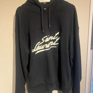Saint Laurent Hoodie - Tjena! Säljer nu mina tvär snygga samt eftertraktade Saint Laurent hoodie i storlek L. Den är i väldigt bra skick och endast använd ett fåtal gånger. Priset är ej hugget i sten så hör av dig vid minsta fundering:)