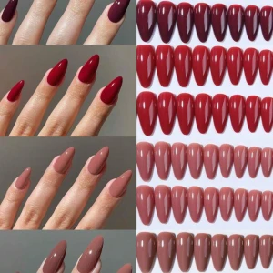 Falska naglar i rött och nude - Säljer ett set med långa, spetsiga falska naglar i flera nyanser av rött, vinrött och nude. Naglarna har en glansig finish och kommer i olika färgtoner från mörkröd till ljusrosa. Perfekt för dig som vill ha snygga och trendiga naglar utan att gå till salong.