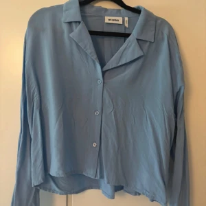 Ljusblå skjorta från Weekday, S - Säljer en ljusblå skjorta från Weekday i storlek S. Skjortan har en avslappnad passform, klassisk krage och knäppning framtill. Tillverkad i mjukt och tunt material, perfekt för en chill och stilren look.