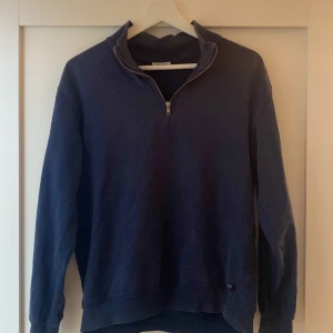 Mörkblå half zip sweatshirt - Mörkblå sweatshirt från Kappahl half zip-dragkedja och hög krage. Tröjan är i mjuk bomull och har långa ärmar samt ribbade muddar vid hals och ärmslut. Perfekt för lager-på-lager och chill dagar.