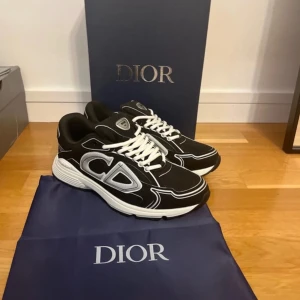 Svarta D30 sneakers med silverdetaljer - Snygga svarta sneakers med stora silvriga loggor på sidorna och vita snören. Skorna har en chunky vit sula och coola kontrastdetaljer i vitt och silver. Perfekta för dig som vill sticka ut med exklusiv streetstyle. Använd 1 gång