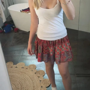 Färgglad kortkjol med mönster - Supersöt kortkjol i flera olika färger med blandade mönster som paisley och grafiska tryck. Kjolen har en smockad midja som är stretchig och ger en skön passform. Perfekt för dig som gillar boho-vibe och färg. Lätt och luftig, passar perfekt till varma dagar. 