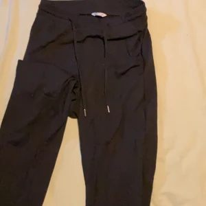 Svarta mjukisbyxor med snörning XS - Svarta mjukisbyxor i storlek XS från Cubus. Byxorna har en bekväm passform med resår i midjan och snörning framtill. Perfekta för chill dagar eller när du vill ha det extra bekvämt. Klassisk stil utan synliga loggor eller mönster.