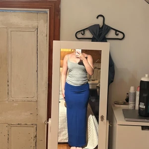 Blå ribbad långkjol från H&M Divided XS - Säljer en snygg blå långkjol från H&M Divided i storlek XS. Kjolen är ribbad och har en tight passform som sitter skönt mot kroppen. Tillverkad i stretchigt material med 92% polyester och 8% elastan. Perfekt för dig som gillar stilrena och bekväma plagg.