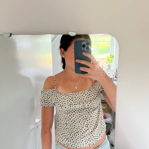 Beige prickig offshoulder topp - Supersöt beige topp med svarta prickar🥰💞 säljer då den tyvär är lite för liten, har inget märke eller storlek men skulle säga att den passar XSS & XS 🥰 Går att ha på två sätt😇