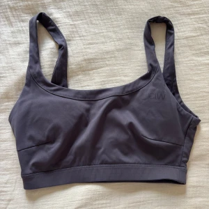 Mörk lila sporttopp från ICANIWILL - Säljer en mörk lila sporttopp från ICANIWILL med breda axelband och rundad halsringning. Toppen är sömlös och har en stilren look, perfekt för träning. Materialet är mjukt och stretchigt syntet som ger bra stöd och komfort.