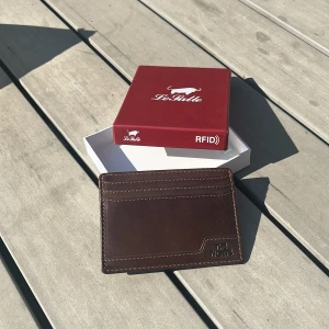 Brun skinnplånbok The Monte - Slimmad brun plånbok från The Monte i äkta skinn med flera kortfack och snygga kontrastsömmar. Perfekt för dig som vill ha en stilren och smidig korthållare i fickan. Kommer i originalförpackning från Le Pelle.
