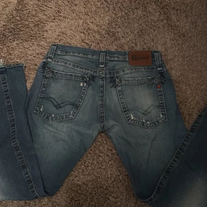 Replay jeans W31 L32  - Snygga blå Replay jeans med slitna detaljer. Säljer för dem är för stora och ser dem inte användas längre fram. Dem är mörkblåa me vitare delar på låren. De är en lite äldre modell men riktigt snygga och i bra skick! Hör av er om ni undrar något eller kom me förslag priset är inte hugget i sten