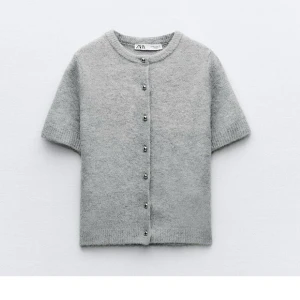 Grå kofta Zara - Grå kofta från Zara med korta ärmar. Koftan har snygga silvriga knappar framtill och är stickad i ett fluffigt material som känns lyxigt. Slutsåld model. Aldrig använd!💕