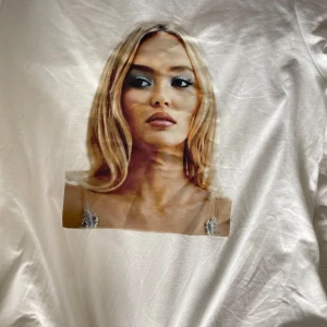 Vit t-shirt med tryck av Lily rose - Vit t-shirt med ett stort tryck av Lily Depp🪩Modellen är figurnära och passar perfekt till ett par jeans eller shorts