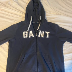 Marinblå hoodie från GANT med dragkedja - Säljer en marinblå hoodie från GANT i storlek M.  Skulle att det är mer som S i storleken 
