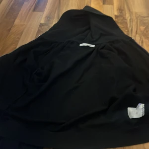 Svart hoodie med dragkedja från 157 - Svart hoodie från 157 med huva och snörning, hel dragkedja framtill och två fickor. Klassisk och enkel design, perfekt till chill dagar. Tillverkad i mjukt material som känns skönt mot huden.