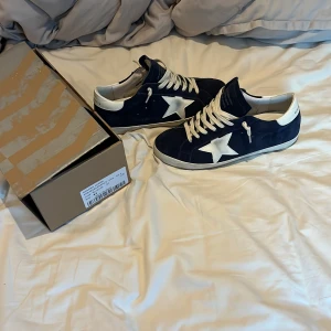 Golden Goose Francy sneakers blå - Golden Goose Francy sneakers i mörkblå mocka med vit stjärndetalj på sidan och vit häl. Skorna har rund tå, platt sula och vita snören. Snygg kontrast mellan blått och vitt, perfekt för dig som gillar streetstyle med lyxig känsla.