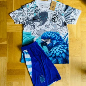 Brazil papegoja T-shirt x Argentina blå shorts  - T-shirt Brazil: 499 / 5̶9̶9̶ kr.                                                                                      Shorts Argentina: 399 / 4̶9̶9̶ kr
