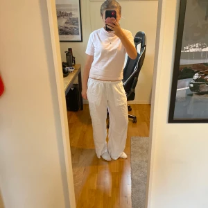 Vita linnebyxor från Gina Tricot XS - Säljer ett par vita linnebyxor från Gina Tricot i storlek XS. Byxorna har en avslappnad loose passform, resår i midjan och raka ben. Materialet är lätt och luftigt linne, perfekt för varma dagar. Snygga att matcha med en enkel t-shirt eller linne. Har används väldigt lite och har inga tecken på användning! Pris kan diskuteras