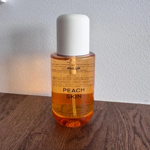 PHLUR Peach Skin 236ml - Fräsch och fruktig Peach Skin från PHLUR. Passar både hår och kropp. Mycket populär och vital på TikTok. Går inte att köpa i Sverige. 