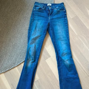 Blå bootcut jeans från ONLY, S/34 - Snygga blå jeans från ONLY med bootcut-ben. Jeansen har normal passform och är tillverkade i mjukt bomullsjeansmaterial.  Innerbenslängd: 77 ”Ytterbenslängd”: 98  midjemått: 31  Lårvidd: 5 (allt i cm)