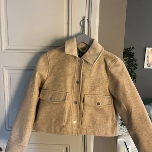 Beige filtjacka - Snygg beige jacka från Zara med klassisk krage och stora fickor framtill. Jackan har raka linjer, tryckknappar och passar dig som gillar en clean och trendig look. Knappast använd!❣️
