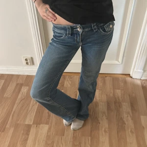 Blå bootcut jeans låg midja - Säljer ett par klassiska blå jeans med bootcut-snitt och låg midja. Använt ganska mycket förr men inte längre men är i bra skick💓 skriv för frågor eller annat🩷