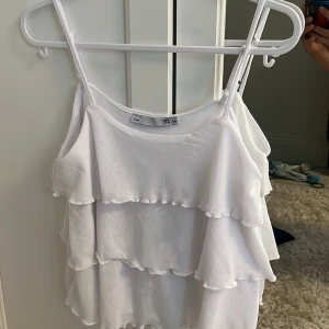 Gulligt vitt volanglinne från 157😇 - Supersöt vit linnetopp från 157 med flera lager volanger. Enkel att matcha med jeans eller kjol för en chill vibe. Passar mig som även brukar ha 150-160, inte äns använd💕