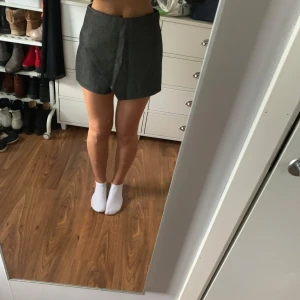 Gråa omlottshorts från Dilvin - Snygga gråa shorts från Dilvin med omlottdesign framtill och fickor bak. De är högmidjade och har en stilren look som passar perfekt till en trendig outfit. Materialet känns lite kraftigare och ger en exklusiv känsla. Säljer dessa för de är för stora för mig.💕