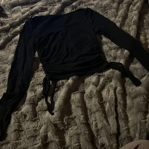 Svart långärmad topp med snörning SHEIN - Svart långärmad topp från SHEIN i ribbat material. Stretchig i materialet