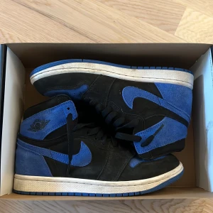 Nike Air Jordan 1 High OG Svart/Blå - Jag säljer ett par Jordan 1 retro og High i en svart blå färg i mocha material. Jag säljer dem för jag har vuxit ut dem.