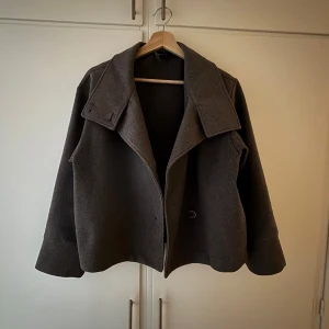 Grå kappa - Jättesnygg grå kappa perfekt till hösten!! Den har tyvärr lite lösa knappar och ett pyttelitet hål i vänstra ärmen men det är ingenting som märks av. !!!Den ser brun ut men den är grå, det är bara ljuset!!! Är stl xs men passar mer som s och den har fickor i sidorna, skriv om ni har fler frågor eller vill ha fler bilder! Nypris 600kr